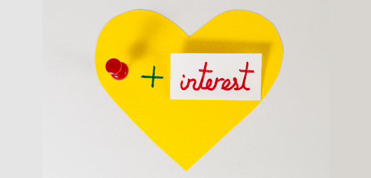 Yellow paper heart with a pushpin followed by "+ interest"