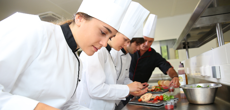 Group of chefs preparing food in kitchen